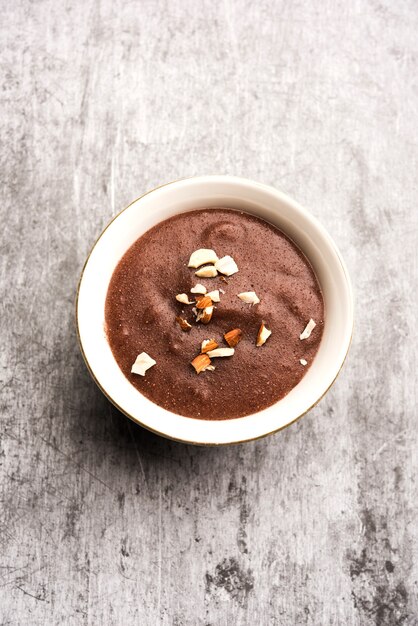 Sweet Ragi Malt oder Healthy Ragi Porridge in einer Schüssel garniert mit zerdrückten Trockenfrüchten