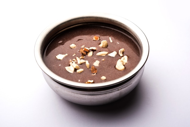 Sweet Ragi Malt ou Healthy Ragi Porridge em uma tigela guarnecida com frutas secas esmagadas