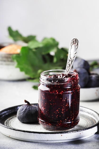 Sweet Red Fig Jam Jar Frische blaue Feigen Hausgemachte Zubereitungen und Konserven Grauer Tabellenhintergrund, Kopienraum