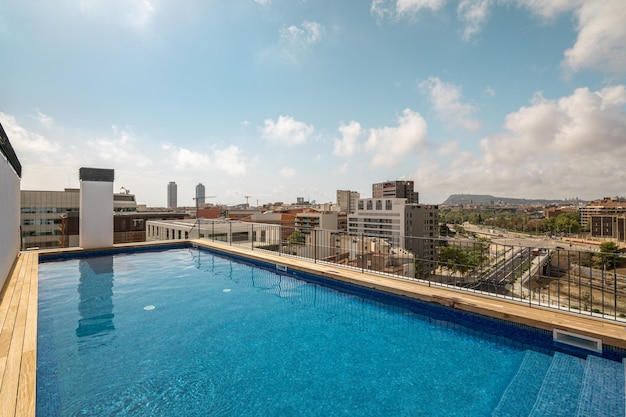 Swimmingpool auf dem Dach mit schöner Aussicht auf die Stadt an einem sonnigen Tag in Barcelona, Spanien