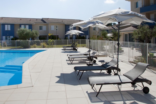 Swimmingpool im Ferienort Sommer mit Stühlen und Sonnenschirm