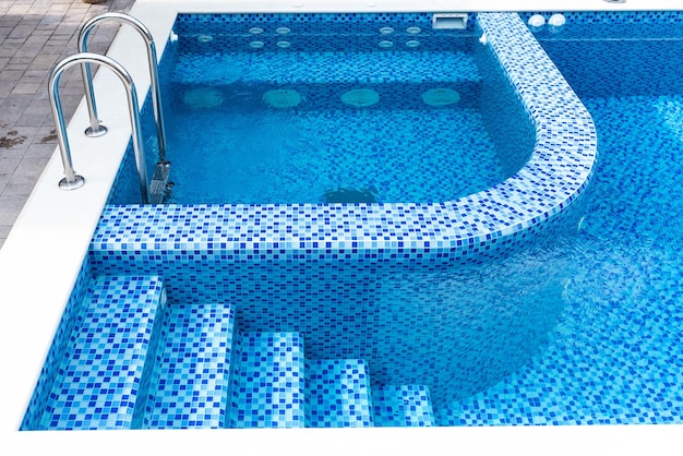 Swimmingpool mit blauen Kacheln Stufen und separater Jacuzzi-Bereich Entspannen Sie sich im Hinterhof eines Landhauses