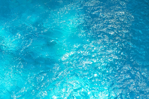 Swimmingpool mit sonnigem Reflexionshintergrund. Abstrakte Wasseroberfläche.