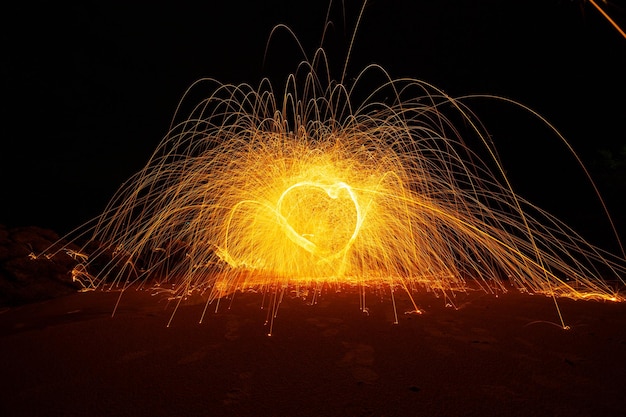 Swing fire Swirl Stahlwolle Lichtfotografie über den Stein mit Reflex im Wasser Schönes Licht in der Sonnenaufgangs- oder Sonnenuntergangszeit lange Belichtungsgeschwindigkeitsbewegungsart