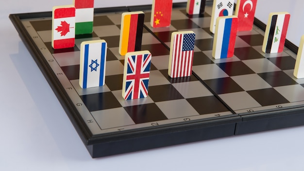 Symbole der Länder auf dem Schachbrett. Konzeptionelles Foto, politische Spiele.