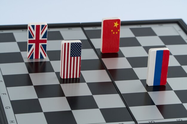 Symbolflagge von Russland, USA, China und England auf dem Schachbrett. Das Konzept des politischen Spiels.