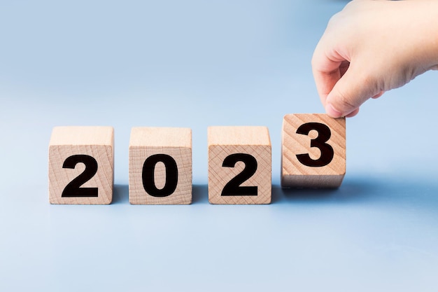 Symbolisieren den wechsel von 2022 zum neuen jahr 2023. 2023 frohes neues jahr konzept.