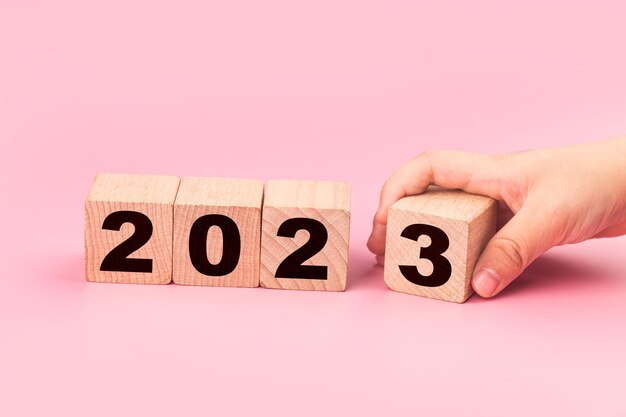 symbolisieren den wechsel von 2022 zum neuen jahr 2023. 2023 frohes neues jahr konzept.