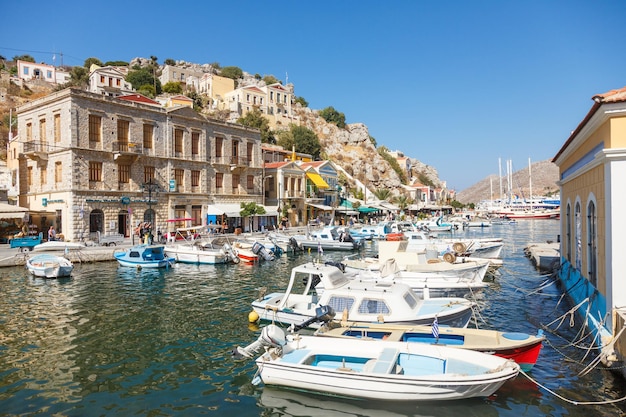 SYMI, GRECIA - septiembre 6,2015: Barcos de pesca amarrados en el puerto de Yialos y una hermosa vista en una isla de color houseson Symi, Grecia. Symi es el destino fácil y más popular para excursiones de un día desde Rh