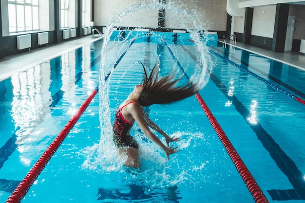 Synchronisiertes Mädchen, das Tricks im Pool ausarbeitet Synchronschwimmsport im Wasser Gesunder Lebensstil