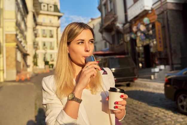 System zum Erhitzen einer Tasse Kaffee aus Tabakpapier in den Händen einer Frau auf der Straße der Stadt