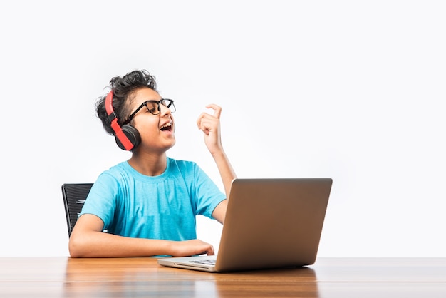 Syudent masculino indiano ou criança estudando on-line usando o laptop. Criança asiática frequentando escola online usando computador