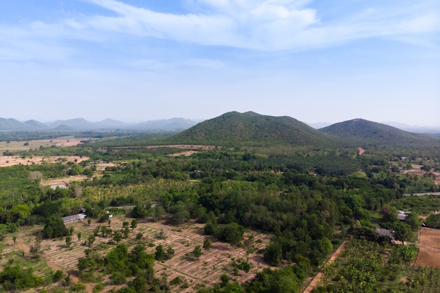 Szenische Landschaft der Brummenschussvogelperspektive des Landwirtschaftsbauernhofes gegen Berg und Naturwald