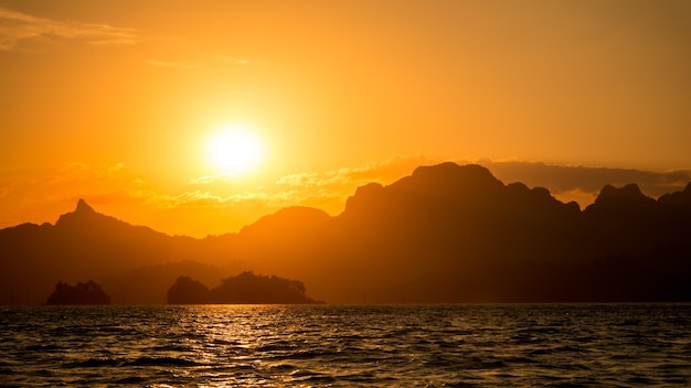 Szenische Sonnenuntergangansicht des drastischen Schattenbildes am Berg refreftion auf Seewasserwellen. Sommer Meer und See