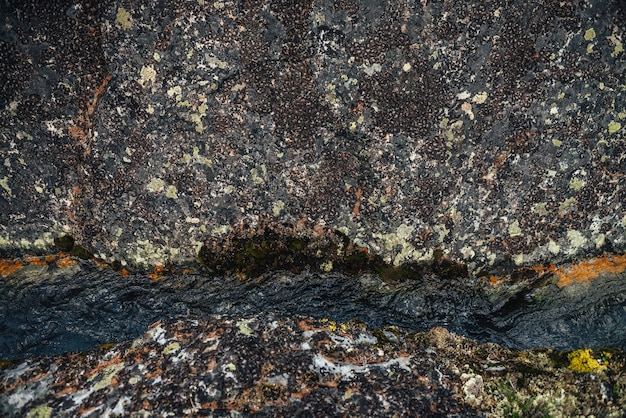 Szenischer Naturhintergrund des türkisfarbenen klaren Wasserstroms zwischen Felsen mit Moosen und Flechten. Stimmungsvolle Berglandschaft mit moosigen Steinen im transparenten Gebirgsbach. Schöner Gebirgsbach.