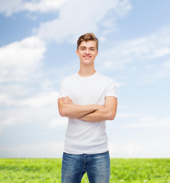 T-Shirt-Design, Sommer, Werbung und People-Konzept - lächelnder junger Mann in leerem weißem T-Shirt über natürlichem Hintergrund