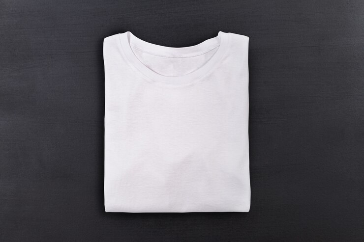 T-shirt dobrada branca sobre fundo preto lousa
