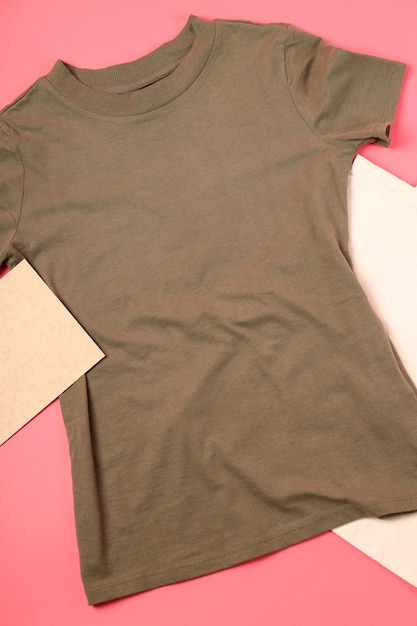 T-shirt em branco, saco e folha de papelão em fundo rosa