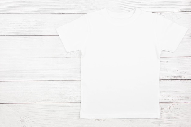 T-Shirt-Mockup aus weißer Baumwolle für Damen auf Holzhintergrund Design-T-Shirt-Vorlage Druckpräsentation Mock-up Ansicht von oben flach gelegt