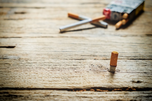 Tabaco no cigarro, deitado sobre uma mesa de madeira.