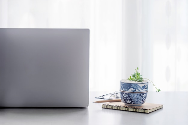 Tabela de mesa de escritório com computador portátil, suprimentos com espaço de cópia no escritório.