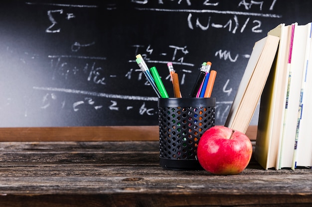 Foto tabelle mit büchern und briefpapier nahe tafel