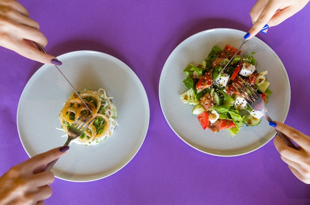 Tabelle mit Draufsicht vieler Salate. Verschiedene Salate auf Betontisch, Ansicht von oben. Gemüsesalat, Salat mit Räucherlachs, Ceviche und Stracciatella.