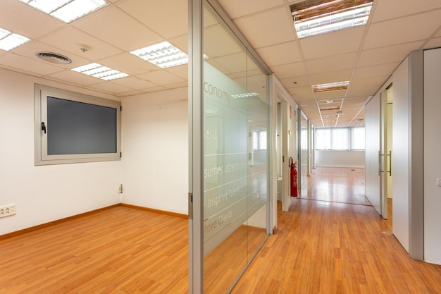 Tabique de cristal que encierra la sala de oficina vacía del pasillo con ventana al final diseño anticuado de