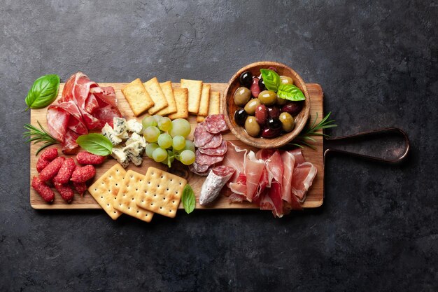 Tabla de antipasto con prosciutto salami crackers queso aceitunas