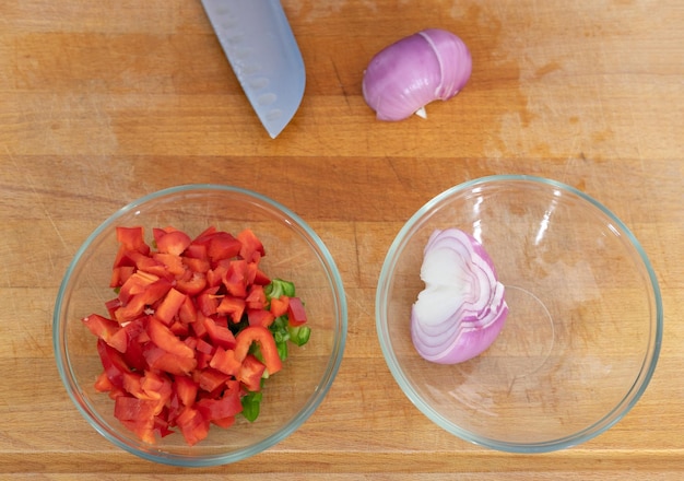 Tabla de cocina con dos tazones con pimientos y cebollas Copiar espacio