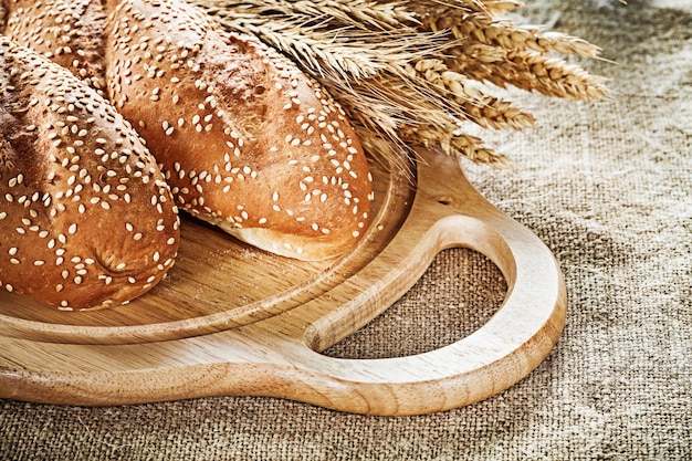 Tabla de cortar baguette orejas de trigo sobre fondo de saqueo vintage