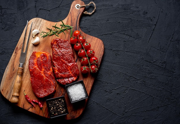 Una tabla de cortar con carne y verduras.