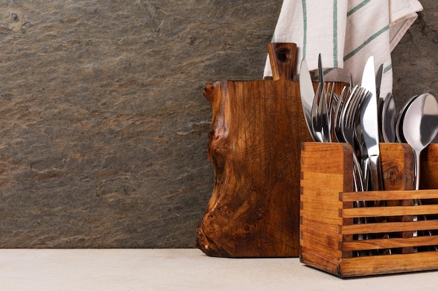 Tabla de cortar y cubiertos en la mesa de la cocina de madera