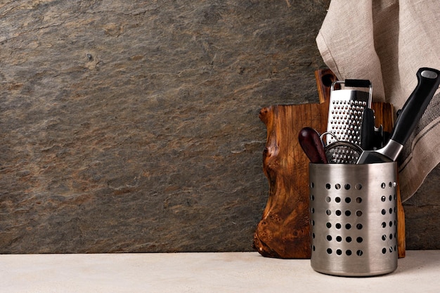 Tabla de cortar y cubiertos en la mesa de la cocina de madera