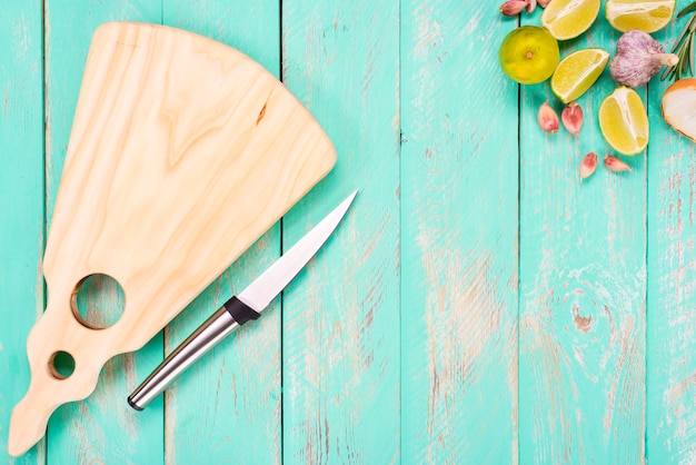 Tabla de cortar con un cuchillo sobre una mesa de madera vintage