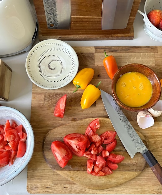Una tabla de cortar con un cuchillo y tomates.