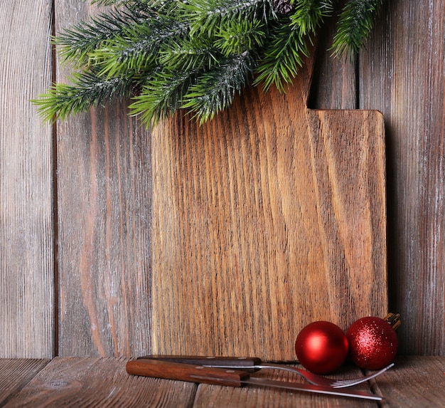 Tabla de cortar con decoración navideña sobre tablones de madera