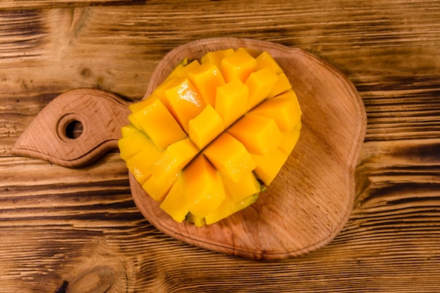 Tabla de cortar con fruta de mango picada en la mesa de madera rústica Vista superior