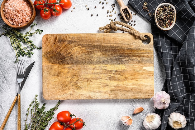 Tabla de cortar de madera en el centro de los ingredientes