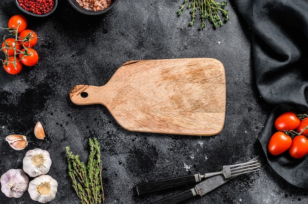 Tabla de cortar de madera en el centro de verduras crudas frescas, verduras