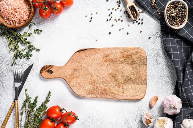 Tabla de cortar de madera en el centro de verduras crudas frescas