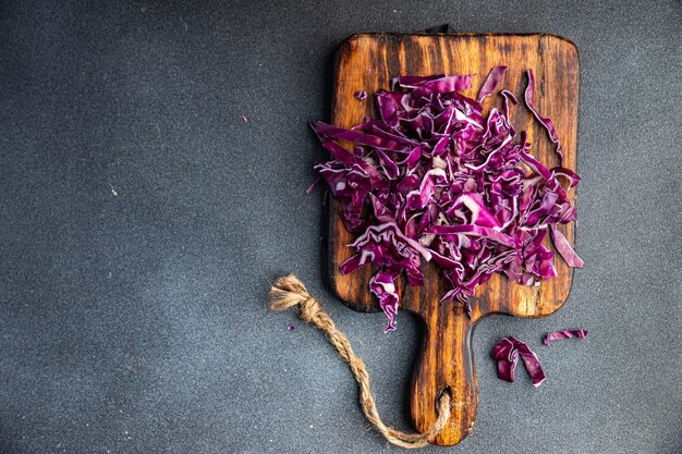 Una tabla de cortar de madera con col roja