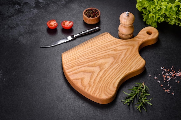 Una tabla de cortar de madera con un cuchillo de cocina con especias y hierbas.