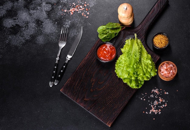 Una tabla de cortar de madera con un cuchillo de cocina con especias y hierbas.