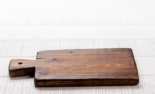 Foto tabla de cortar de madera en la mesa de la cocina blanca