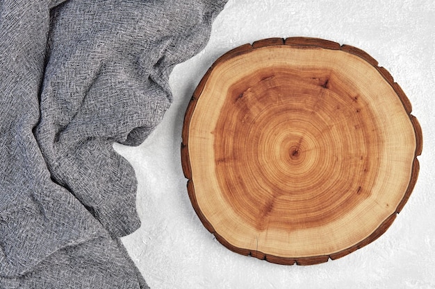 Tabla de cortar de madera o posavasos y toalla de cocina gris en un