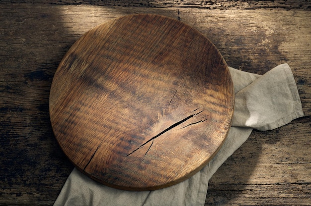 Foto tabla de cortar de madera redonda sobre la mesa de la cocina rústica, vista superior