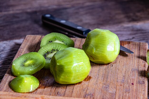 Una tabla de cortar de madera con rodajas de kiwi.