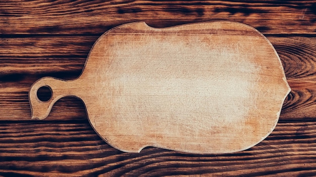 Tabla de cortar de madera sobre fondo de mesa marrón