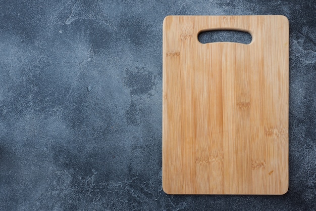 Tabla de cortar de madera vacía en la mesa de la cocina